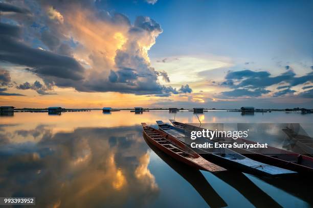 fishing boat and reflexion of clouds on sunset - reflexion stock pictures, royalty-free photos & images