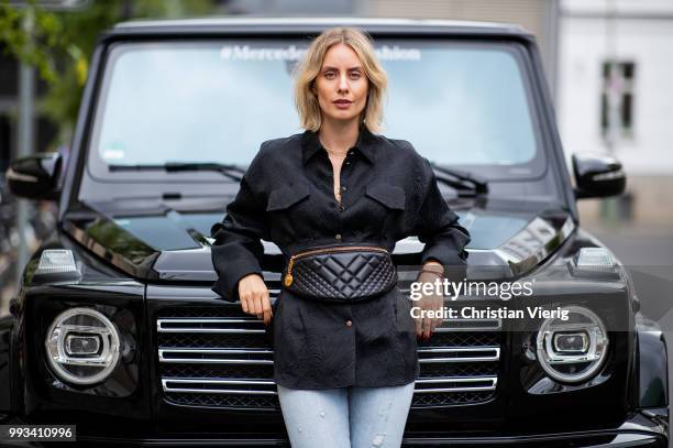 Lisa Hahnbueck wearing a black Dorothee Schumacher button shirt, Versace fanny belt bag, cropped denim jeans Levis, Gucci shoes seen during the...