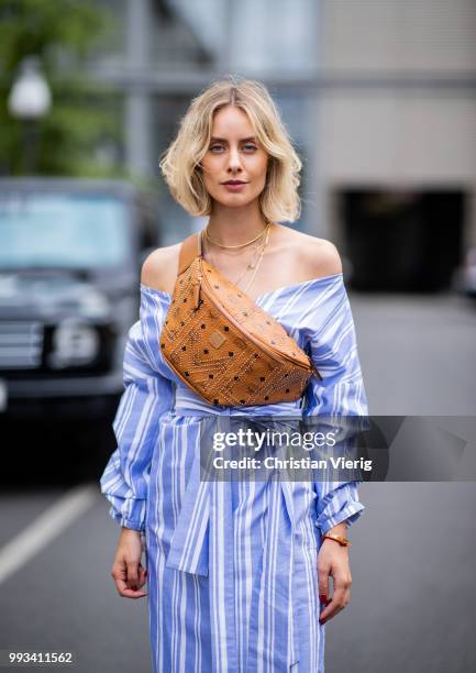 Lisa Hahnbueck wearing striped off shoulder dress Mykke Hofmann, MCM Stark fanny belt bag, Hermes Oran sandals seen during the Berlin Fashion Week...