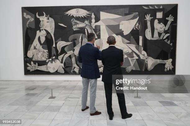 In this handout from the Casa Real - King Felipe VI of Spain and former President Barack Obama view Picasso's "Guernica" as they visit Reina Sofia...