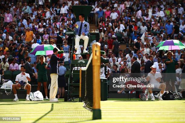 Novak Djokovic of Serbia and Kyle Edmund of Great Britain take a break in play in their Men's Singles third round match on day six of the Wimbledon...