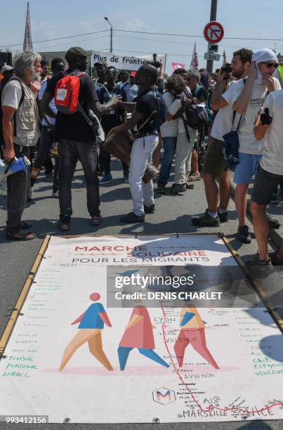 People take part in a "solidarity" march in support of migrants in Calais on July 7, 2018. - Several hundred people took part in the march, organised...