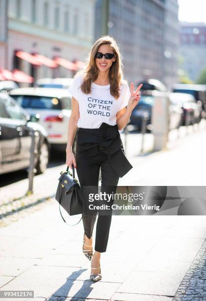 Alexandra Lapp wearing Cool Ambition Semi Loose Fit Pants in black from Dorothee Schumacher with a high waist, white strong statement shirt saying...