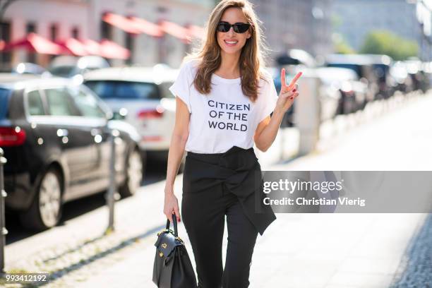 Alexandra Lapp wearing Cool Ambition Semi Loose Fit Pants in black from Dorothee Schumacher with a high waist, white strong statement shirt saying...