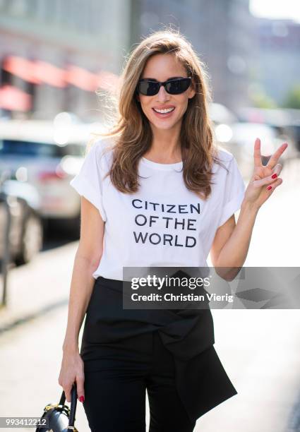 Alexandra Lapp wearing Cool Ambition Semi Loose Fit Pants in black from Dorothee Schumacher with a high waist, white strong statement shirt saying...