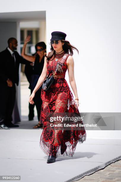Araya Hargate wears a red lace dress and a black hat , outside Dior, during Paris Fashion Week Haute Couture Fall Winter 2018/2019, on July 2, 2018...