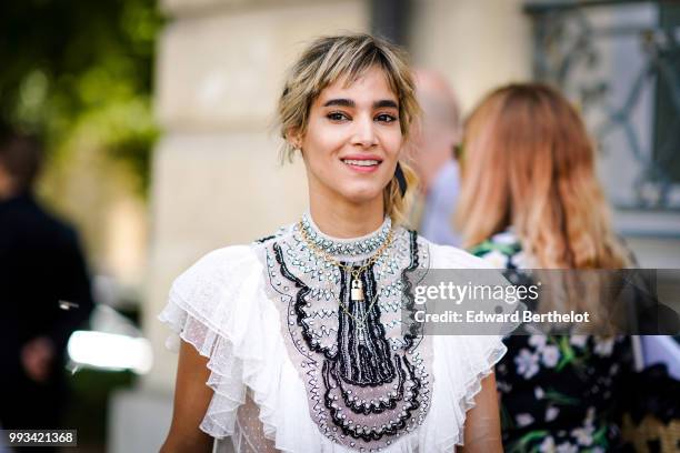 Actress Sofia Boutella wears a white ruffled lace top, a black lace skirt , outside Dior, during Paris Fashion Week Haute Couture Fall Winter...