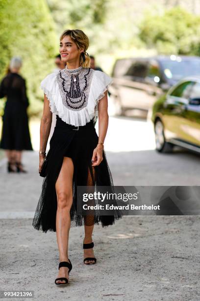 Actress Sofia Boutella wears a white ruffled lace top, a black lace skirt , outside Dior, during Paris Fashion Week Haute Couture Fall Winter...