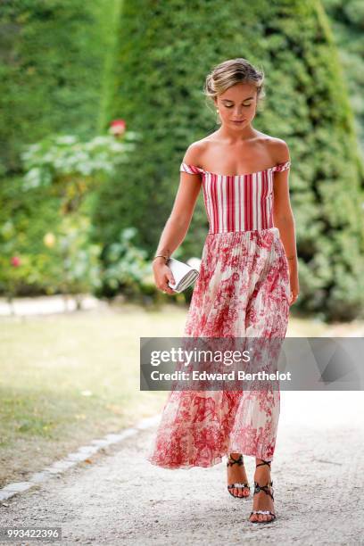 Amelia Windsor wears a red off-shoulder striped top, a white and red pleated skirt with floral prints, outside Dior, during Paris Fashion Week Haute...