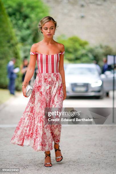 Amelia Windsor wears a red off-shoulder striped top, a white and red pleated skirt with floral prints, outside Dior, during Paris Fashion Week Haute...