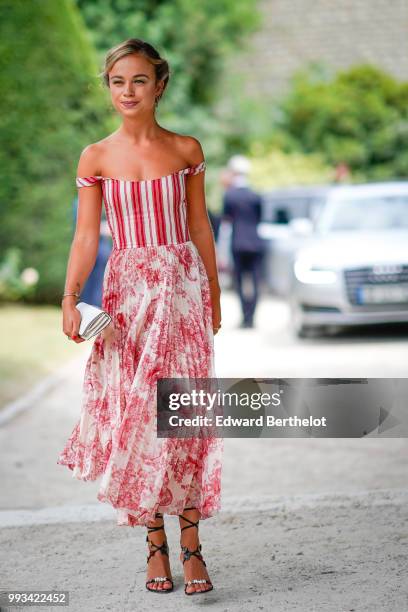 Amelia Windsor wears a red off-shoulder striped top, a white and red pleated skirt with floral prints, outside Dior, during Paris Fashion Week Haute...