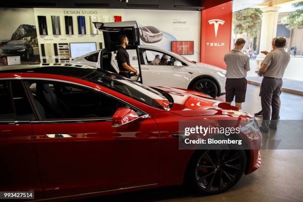 Customers view Tesla Inc. Model S and Model X electric vehicles on display at the company's showroom in Newport Beach, California, U.S., on Friday,...