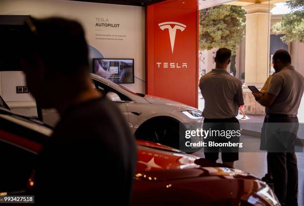 Customers browse vehicles at the Tesla Inc. Showroom in Newport Beach, California, U.S., on Friday, July 6, 2018. Tesla Inc. Reached a milestone...