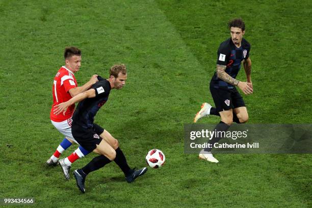 Ivan Strinic of Croatia is challenged by Aleksandr Golovin of Russia during the 2018 FIFA World Cup Russia Quarter Final match between Russia and...