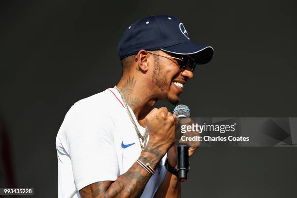 Lewis Hamilton of Great Britain and Mercedes GP talks to fans on the Fan Stage after qualifying for the Formula One Grand Prix of Great Britain at...