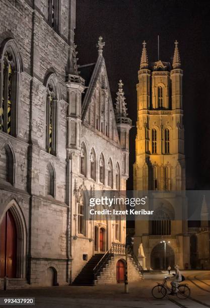 cyclist passing  along ghent's historical buildings, at night, flanders, belgium - east flanders stock pictures, royalty-free photos & images