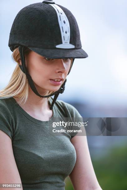 mujer rubia con casco de montar a caballo - equipo de formación fotografías e imágenes de stock