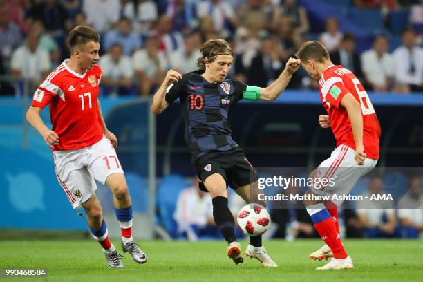 Luka Modric of Croatia competes with Aleksandr Golovin of Russia and Denis Cheryshev of Russia during the 2018 FIFA World Cup Russia Quarter Final...