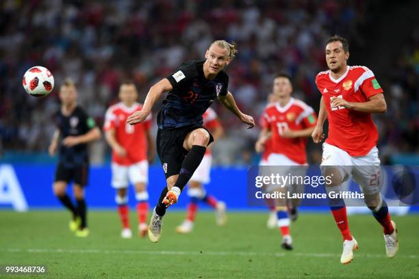 Domagoj Vida of Croatia passes the ball under pressure from Artem Dzyuba of Russia during the 2018 FIFA World Cup Russia Quarter Final match between...