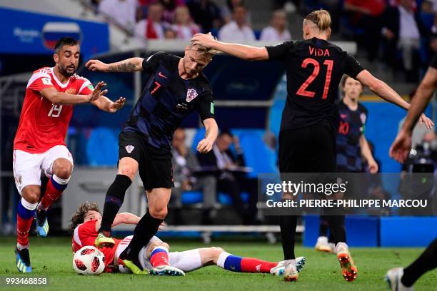 Russia's midfielder Alexander Samedov and Russia's defender Mario Fernandes challenge Croatia's midfielder Ivan Rakitic and Croatia's defender...