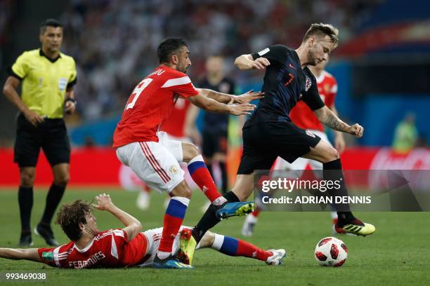 Croatia's midfielder Ivan Rakitic is tackled by Russia's defender Mario Fernandes and Russia's midfielder Alexander Samedov during the Russia 2018...