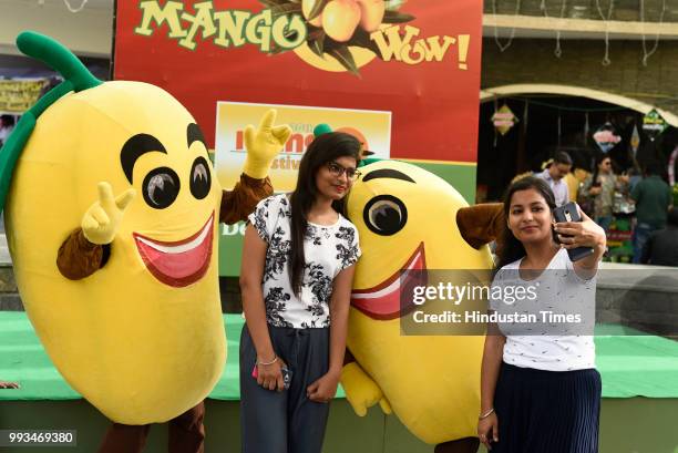 Girls take selfies during Mango Festival at Dilli Haat in Janakpuri, on July 7, 2018 in New Delhi, India. The three day festival is being organized...