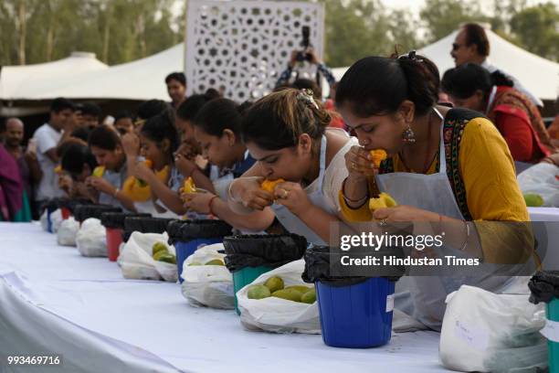 Participants for the Mango Eating Competition eat mangoes during Mango Festival at Dilli Haat in Janakpuri, on July 7, 2018 in New Delhi, India. The...