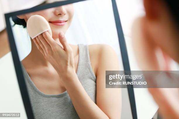 woman applying face powder - runstudio foto e immagini stock