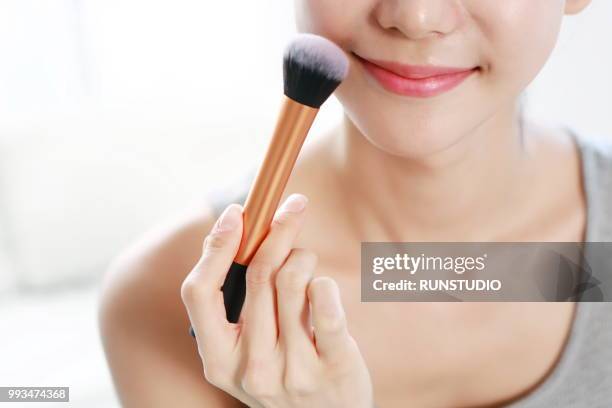 woman applying make-up with brush - runstudio foto e immagini stock