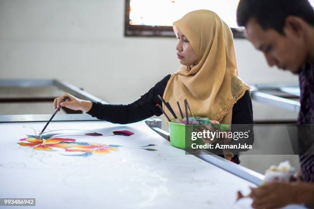 vrouw kleuren de batik in de werkplaats - colouring stockfoto's en -beelden