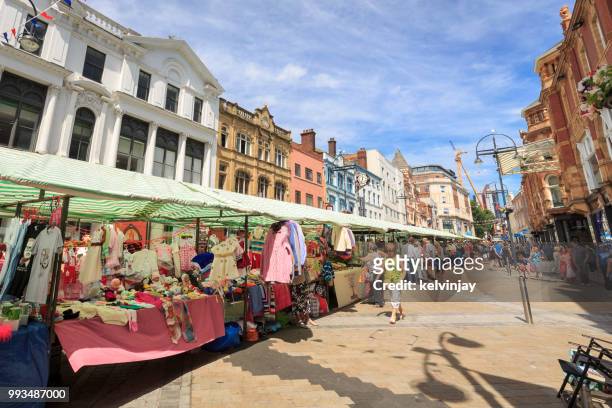 outdoor market and shoppers walking in a pedestrianised area of leeds - kelvinjay stock pictures, royalty-free photos & images