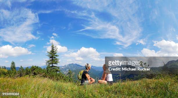 mother and daughter resting on weisenbachkopf mountain, with view to the tegernsee mountains, wildbad kreuth, bavaria, germany - miesbach stockfoto's en -beelden