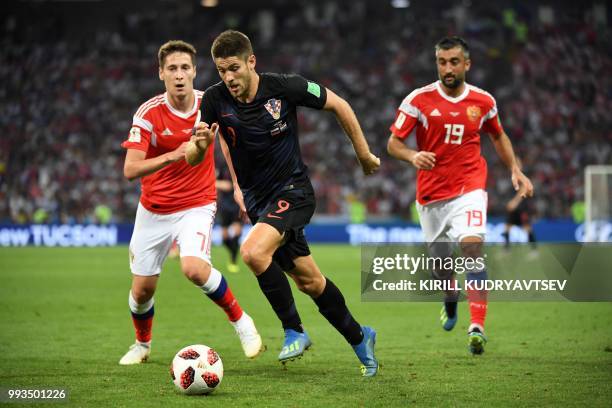 Russia's midfielder Daler Kuzyaev, Croatia's forward Andrej Kramaric and Russia's midfielder Alexander Samedov vie for the ball during the Russia...