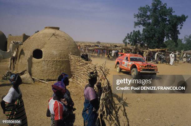 Les concurrents traversent un village dans l'étape Tahoua-Niamey du Rallye Paris-Dakar, le 13 janvier 1987 au Niger.