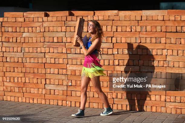 Visitor helps to dismantle and take a brick from Mexican artist Bosco Sodi's artwork Muro, a wall built on London's South Bank to protest against US...