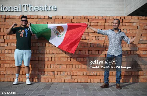Visitors holding a Mexican flag help to dismantle and take a brick from Mexican artist Bosco Sodi's artwork Muro, a wall built on London's South Bank...