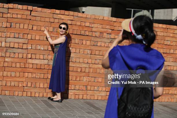 Visitor poses next to Mexican artist Bosco Sodi's artwork Muro, a wall built on London's South Bank to protest against US President Donald Trump. The...
