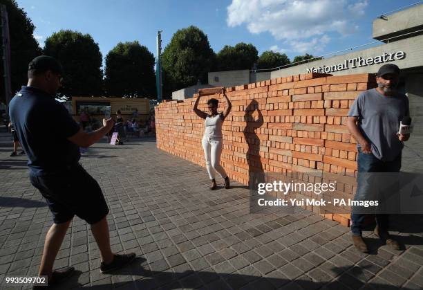 Visitors help to dismantle and take a brick from Mexican artist Bosco Sodi's artwork Muro, a wall built on London's South Bank to protest against US...