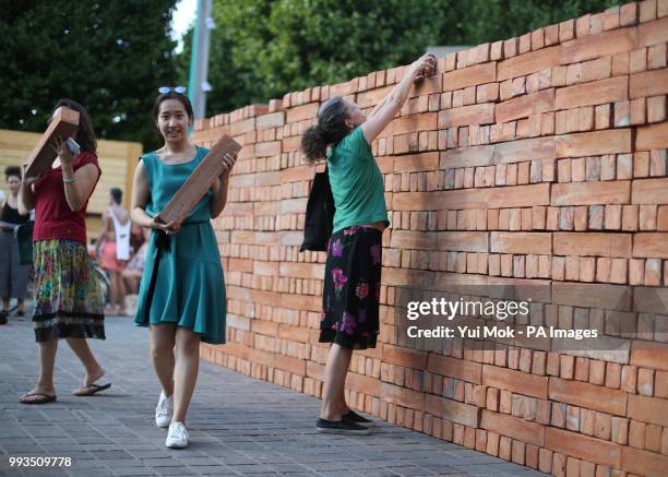 Visitors help to dismantle and take a brick from Mexican artist Bosco Sodi's artwork Muro, a wall built on London's South Bank to protest against US...