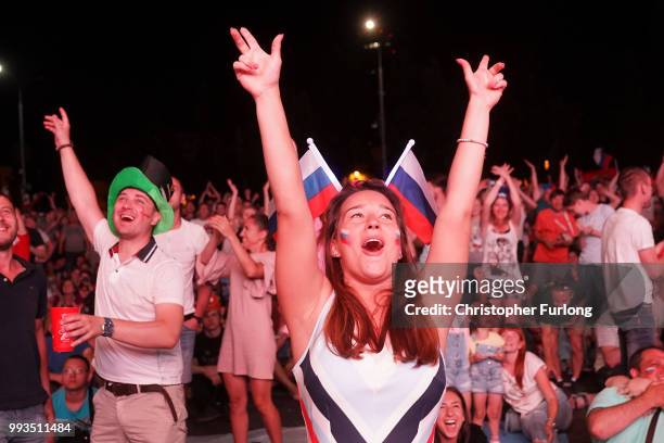 Russian football fans celebrate their team scoring as they watch a giant tv screen at the Samara FIFA fanfest on July 7, 2018 in Samara, Russia. The...