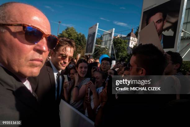 British actor Robert Pattinson poses for photos with his fans as he arrives on the red carpet during the closing ceremony at the 53rd Karlovy Vary...