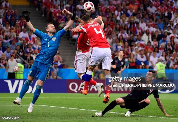 Croatia's forward Mario Mandzukic reacts as Russia's goalkeeper Igor Akinfeev jumps to punch the ball with Russia's defender Sergey Ignashevich and...