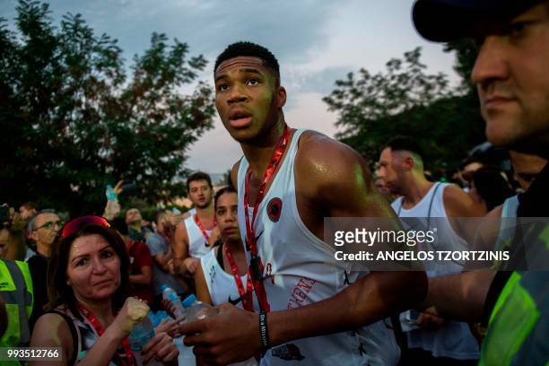 All-Star and Milwaukee Bucks Greek basketball player Giannis Antetokounmpo looks on after crossing the finish line of a 5km charity race along with...