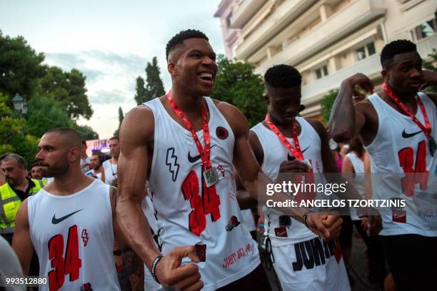 All-Star and Milwaukee Bucks Greek basketball player Giannis Antetokounmpo reacts after crossing the finish line of a 5km charity race along with...