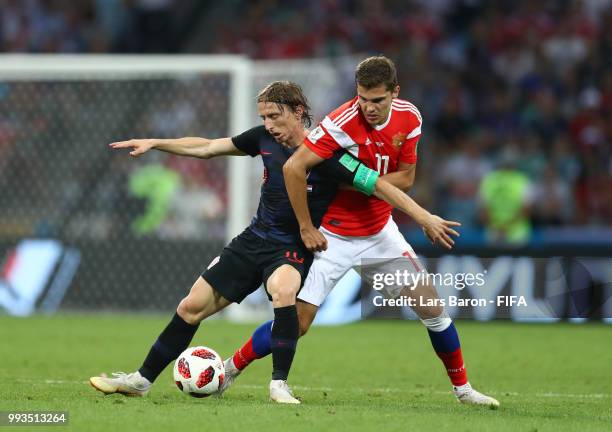 Luka Modric of Croatia is challenged by Roman Zobnin of Russia during the 2018 FIFA World Cup Russia Quarter Final match between Russia and Croatia...