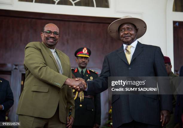 Sudan President Omar al Bashir shakes hands with his Uganda counterpart Yoweri Museveni at Uganda's statehouse in Entebbe on July 7, 2018 before a...