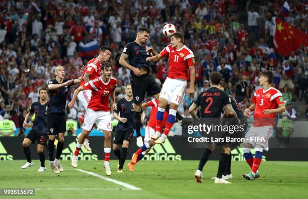 Dejan Lovren of Croatia wins a header over Roman Zobnin of Russia during the 2018 FIFA World Cup Russia Quarter Final match between Russia and...