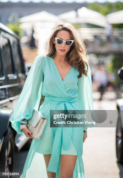 Alexandra Lapp wearing a long shine through dress in turquoise by Lana Mueller, a 2.55 silver handbag by Chanel, two tone Mahnolo Blahnik heels in...