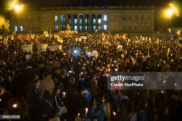 Demonstrators light candles during a candle light vigil for slain activists who have been killed since the signing of the peace accords in Colombia,...