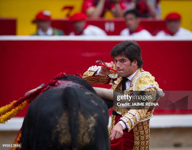 Spanish matador Jose Garrido stabs Puerto de San Lorenzo's fighting bull with a sword during the first bullfight of the San Fermin Festival in...